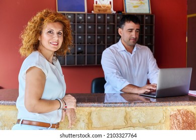 Small Resort Staff At Reception. Portrait Of Female Hotel Owner