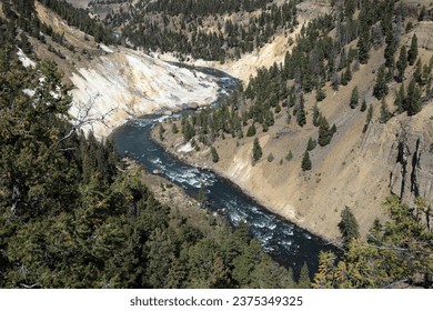 a small river with a large waterfall flows into a deep canyon