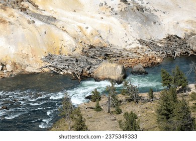 a small river with a large waterfall flows into a deep canyon