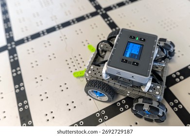 A small robot navigates a grid-like path, showing off its technology and sensors.