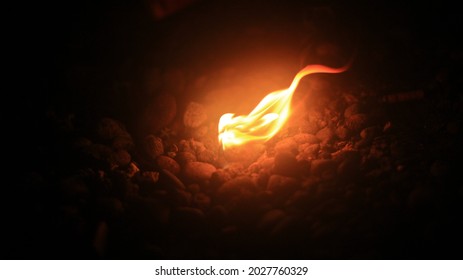 a small rock touching by fire - Shutterstock ID 2027760329