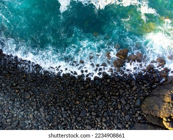 Small rocks and pebbles being washed by ocean waves