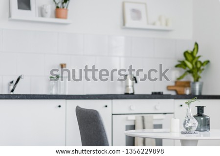 Small, round dining table standing in a white kitchen