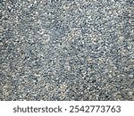 Small round stones texture background. Rough surface of small pebble stone. Abstract background paving consisting of small pebbles embedded in cement