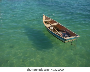 Small Row Boat Floating On Clear Water