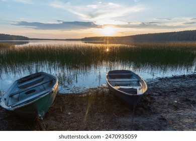 Small rowboats lay on the lake coast under sunset sky, Karelian landscape photo  - Powered by Shutterstock