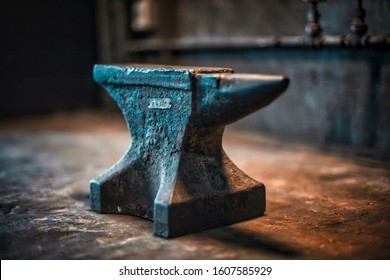 Small rustic blacksmithing anvil on iron surface. 