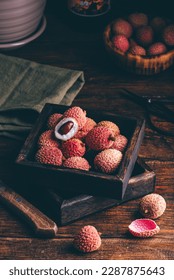Small Rustic Box Full of Lychee Fruits on Wooden Table