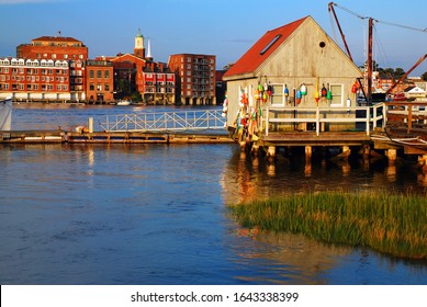 A small rustic fishing shack stands across more modern buildings in Portsmouth, New Hampshire