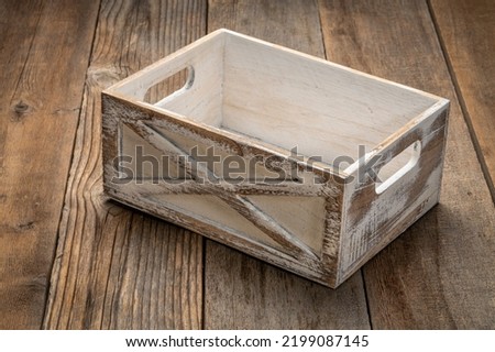 small rustic, white painted,  storage crate against weathered wood