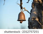 small rusty bell hanging on a tree