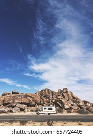 Small RV On The Road In Front Of Rock Pile