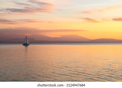 Small sailboat on Lake Geneva at sunset from the banks in Morges (Canton of Vaud, Switzerland)