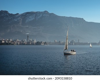 Small Sailing Boat In Front Of The City Of Lecco, On Lake Como (Italy)