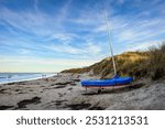 Small Sailing boat on Low Newton Beach, also known as Low Newton-by-the-sea it is a small fishing village on the North Sea coastline in Northumberland