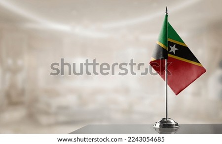 A small Saint Kitts and Nevis flag on an abstract blurry background.