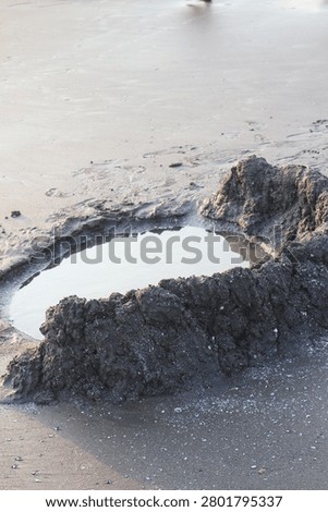 Small Sand Digging Hole on Beach for Play Activity with Natural Coastal Outdoor Scene View
