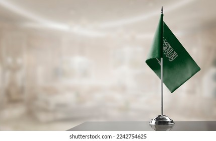 A small Saudi Arabia flag on an abstract blurry background. - Shutterstock ID 2242754625