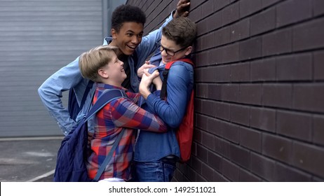Small schoolboy bullying taller student to assert power, self-affirmation