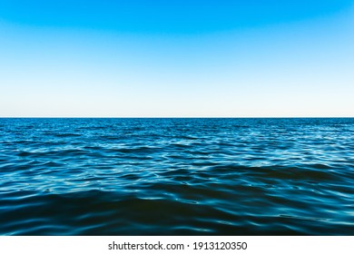 Small Sea Waves Against The Blue Sky And White Horizon