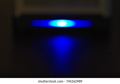 Small Server With Blue Light Glowing In Dark Room. Calgary, Alberta, Canada.