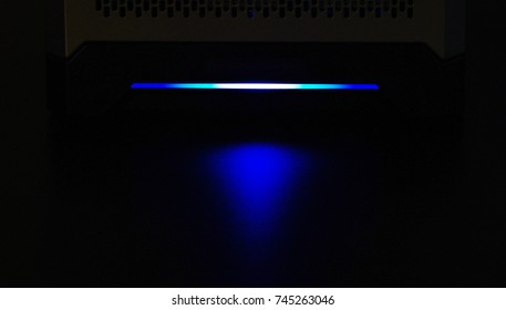 Small Server With Blue Light Glowing In Dark Room. Calgary, Alberta, Canada.