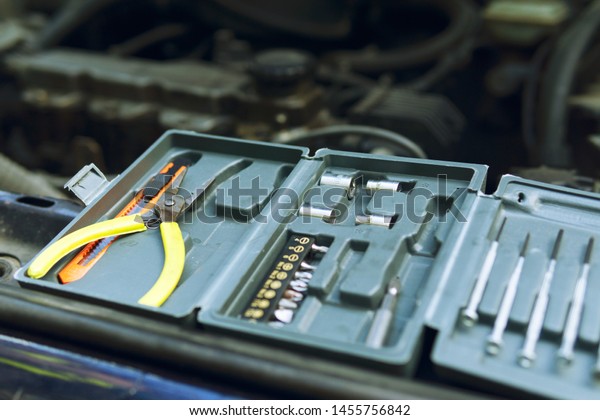 A small set of\
tools, open It stands on the hood of the car. preparing for a small\
engine repair.