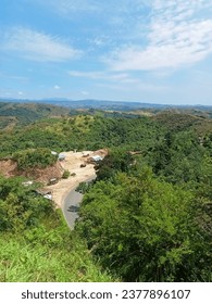 a small settlement located in a valley between forests and hills
