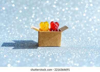 Small Shipping Box With Gummy Bears Isolated On A Glittering Background With Copy Space. Party Supplies Concept.