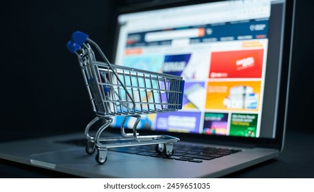 Small shopping cart on a laptop keyboard signifies convenience in digital purchases - Powered by Shutterstock