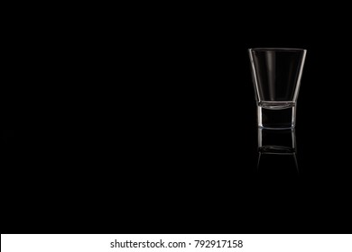 A Small Shot Glass Of Tequila, Vodka Or Whiskey On A Black Background. Place For Your Text.