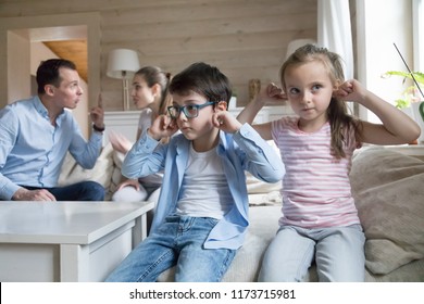 Small siblings close ear with fingers suffering from parents arguing, refuse to hear mom and dad fighting, boy and girl upset with adult quarreling at home. Family conflict concept, marriage break up - Powered by Shutterstock