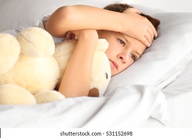 Small Sick Boy With Teddy Bear In Bed