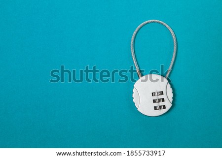 Small silver iron cipher lock with a coded set on blue background