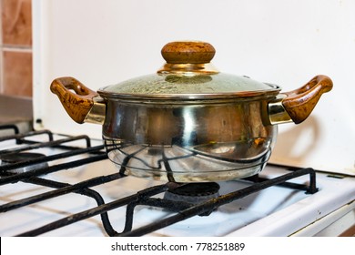 A small silver Pot on a gas stove - Shutterstock ID 778251889