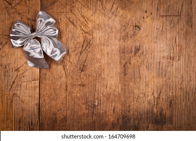 Small silver ribbon on rustic wooden background, Christmas concept 