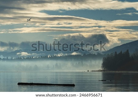 A small single engine plane makes its way in for a landing among the mountains in Comox, BC.