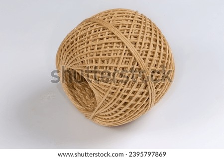 Small skein of the brown synthetic twine without spool on a white background
