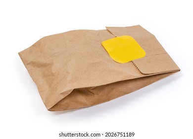 Small Slightly Crumpled Packing Bag Made With Kraft Paper, Sealed With Yellow Sticker On A White Background
