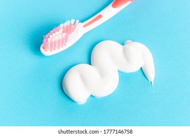 A Small Smear Of Toothpaste And Toothbrush On A Blue Background