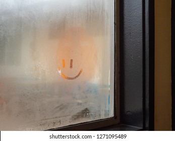 Small Smiley Face Drawn In Condensation And Foggy Window In Restaurant