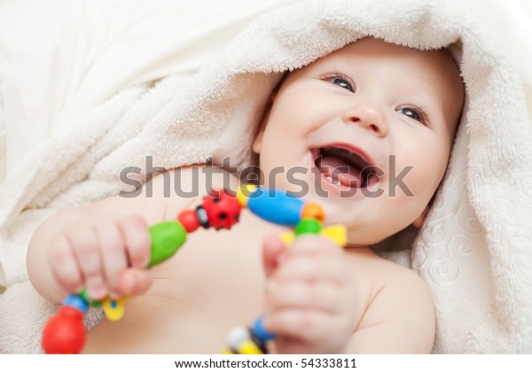 Small smiling baby with a
toy