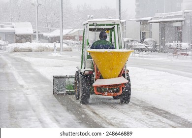 Small Snowplow Removing Snow From Sidewalk And Sprinkled Salt Antifreeze