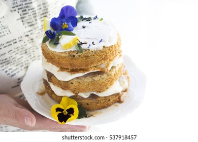 Small Spring Rustic Style Cake on White Service Plate Decorated, White Cream, Violets . Teapot, Flowers on Blade, Top View