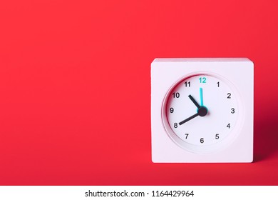 small square white clock on a red background