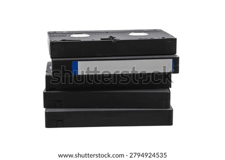 A small stack of black retro VHS videotapes isolated on a clean white background.