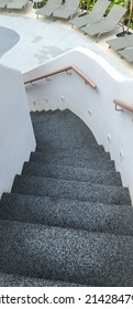 The Small Staircase Has A Black Rubber Floor To Prevent Slipping When Wet And Wooden Handrails As Well As Nighttime Walkway Lighting Embedded In The Wall. The Stairs Leading To Pool With Beach Chairs.