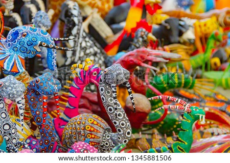 Small stand full of traditional Mexican alebrijes painted in many colors and shapes made by artisans from Michoacan