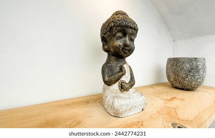 Small statue decorations for table and interior, little buddha statue modern simplistic house environment with several pottery and wooden table