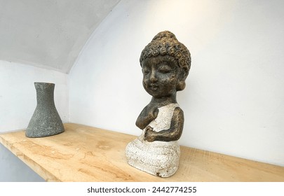 Small statue decorations for table and interior, little buddha statue modern simplistic house environment with several pottery and wooden table